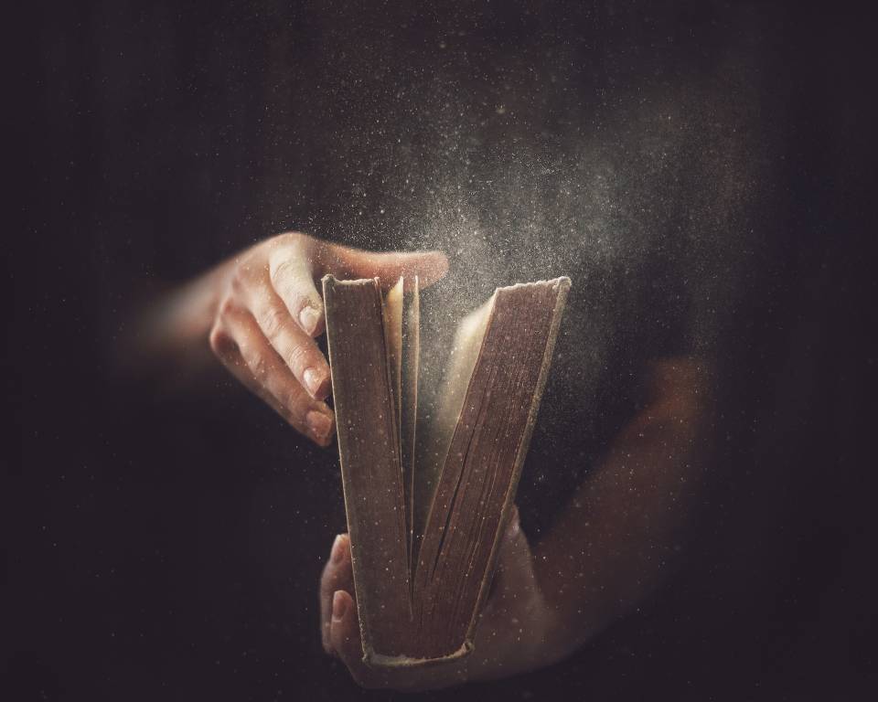 Old book being opened Old, dusty book held in two hands
