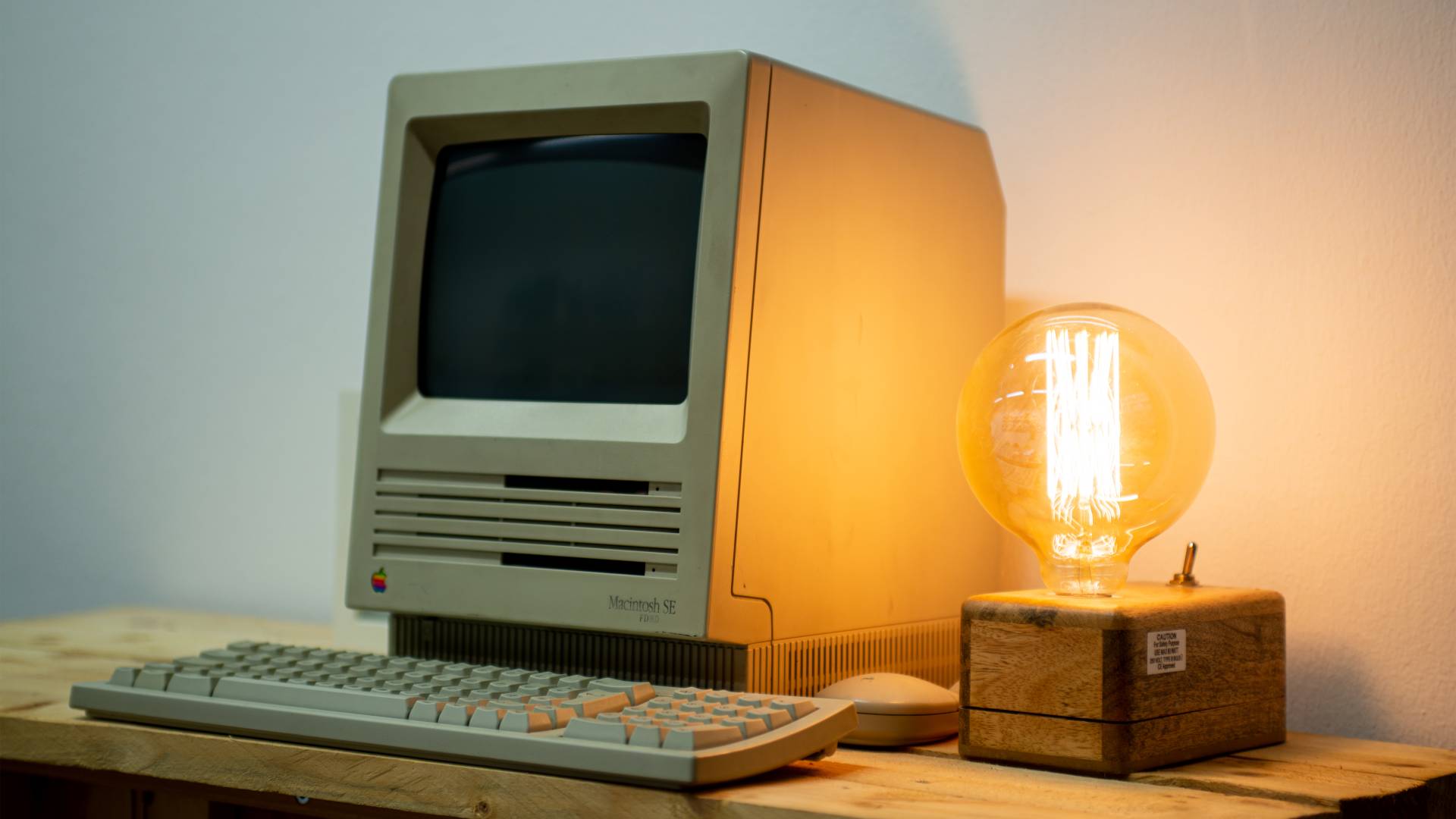 Arbeitsplatz Ein alter Rechner mit leuchtender Glühbirne